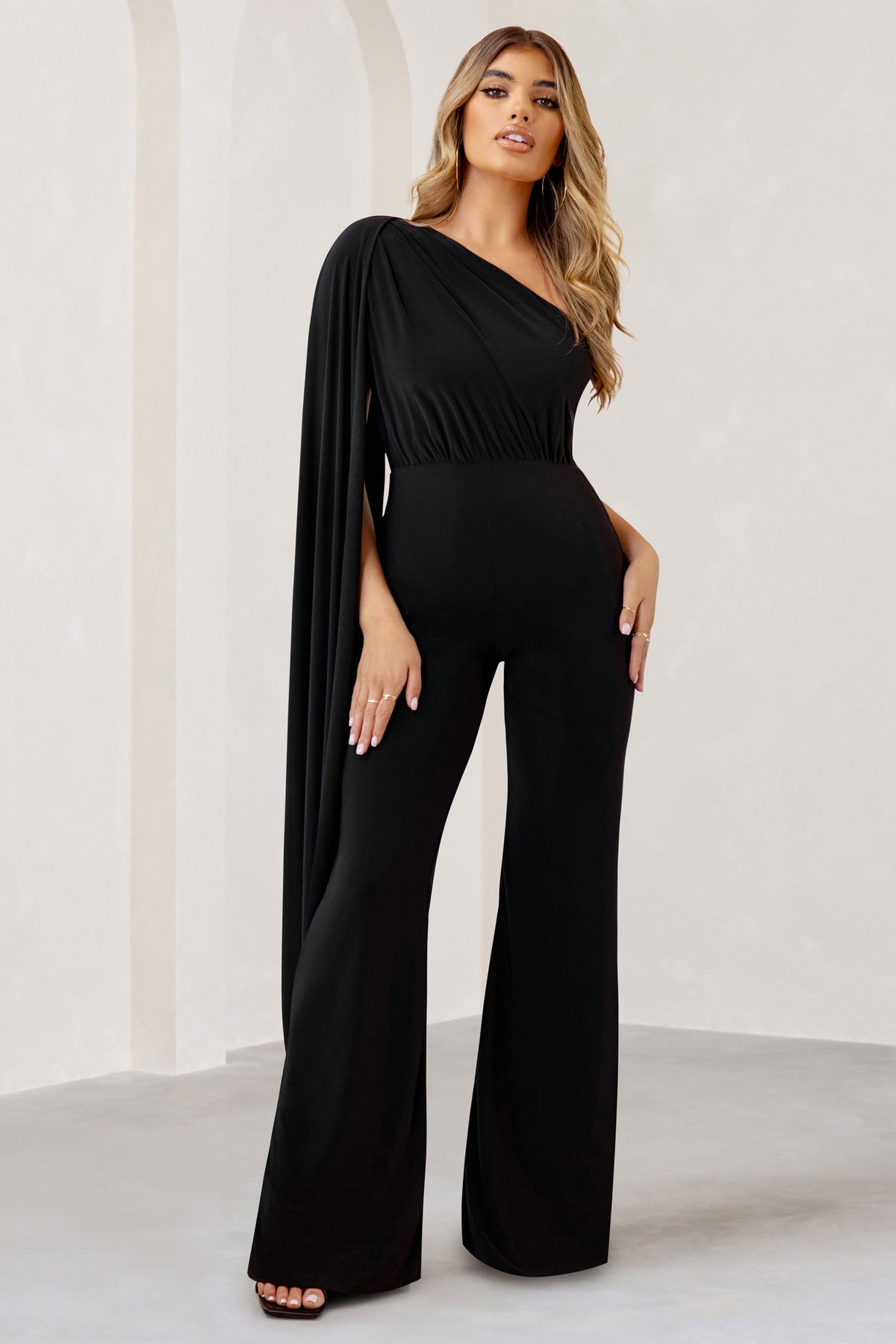Aurora | Zwarte Jumpsuit Met Een Cape Mouw En Blote Schouder