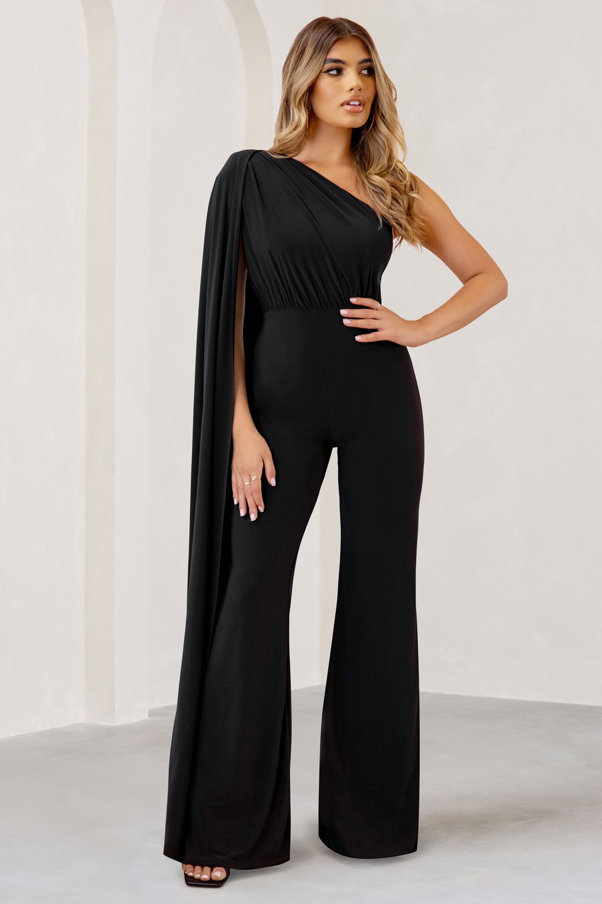Aurora | Zwarte Jumpsuit Met Een Cape Mouw En Blote Schouder